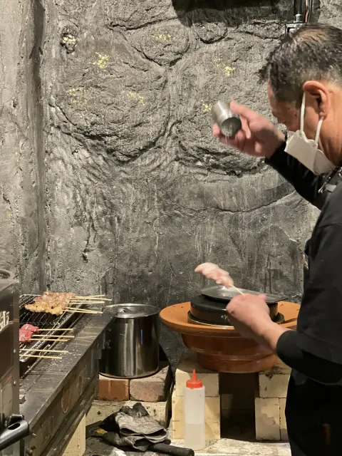 高い位置から塩を振る店主