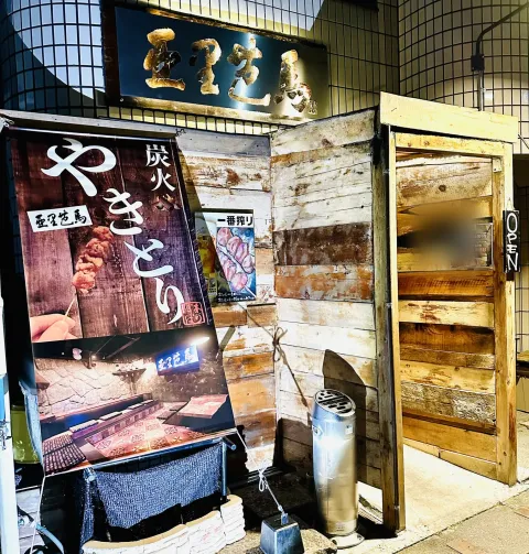 店舗の外観。看板と「炭火やきとり」のタペストリーが目印